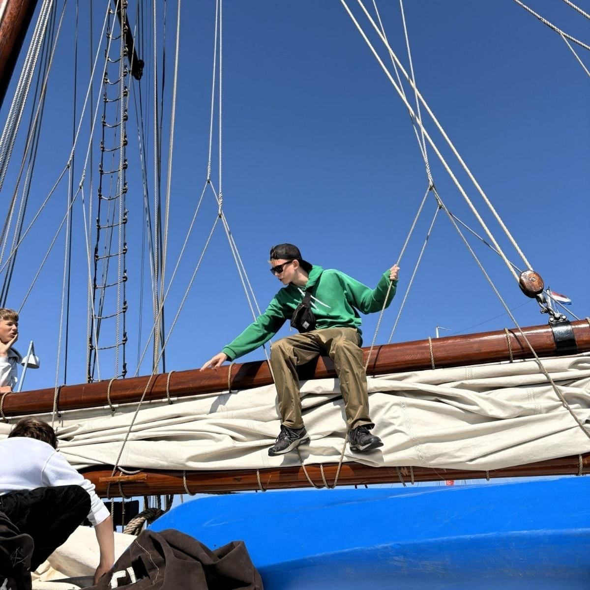 guy on boom square (1) teenage boy sitting on the boom of a tall ship
